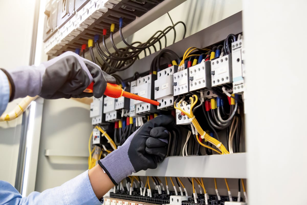 Electricians work to connect electric wires in the system, switchboard, electrical system in Control cabinet.